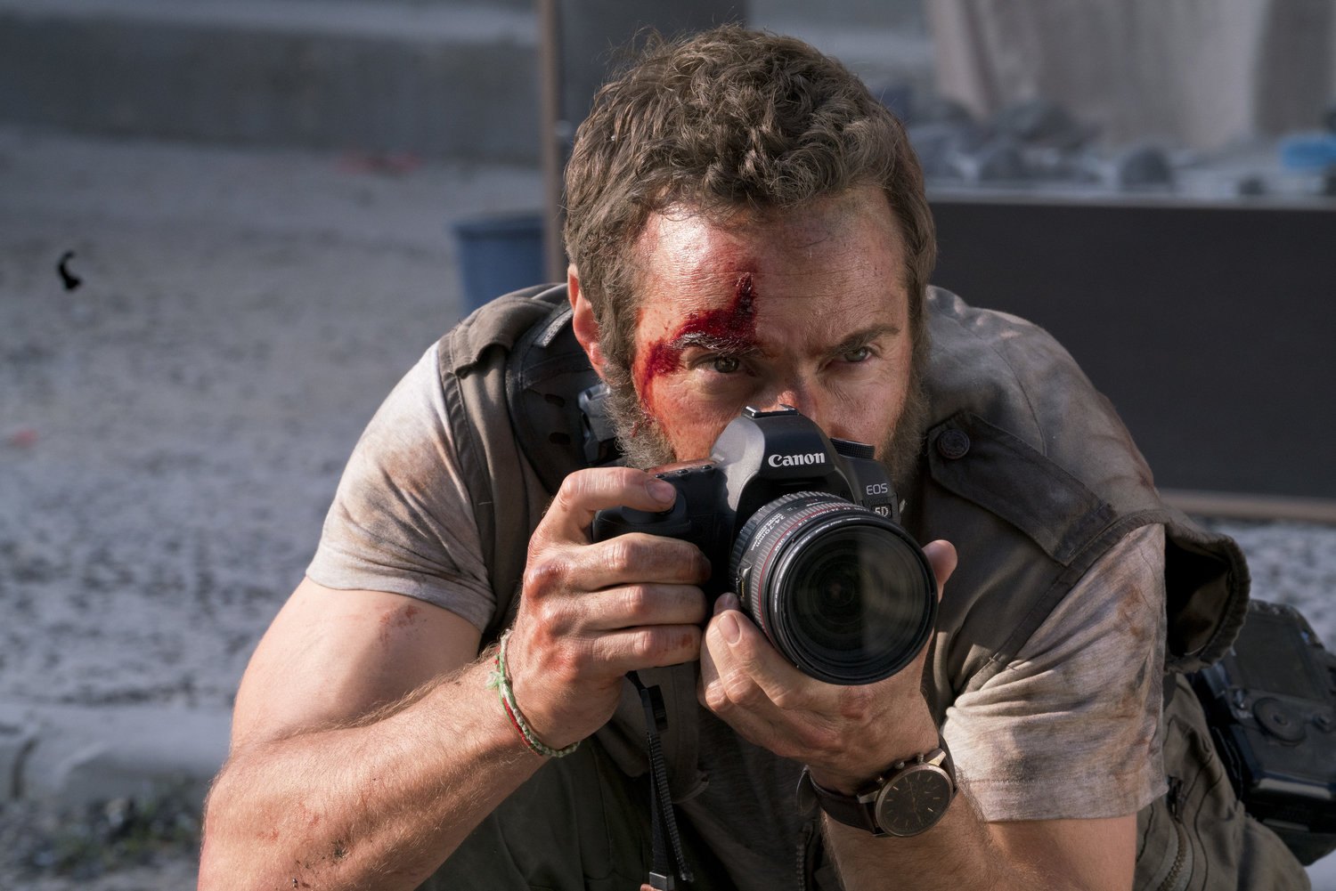Alessandro Nivola as Lee Berger, camera raised, in Chimerica