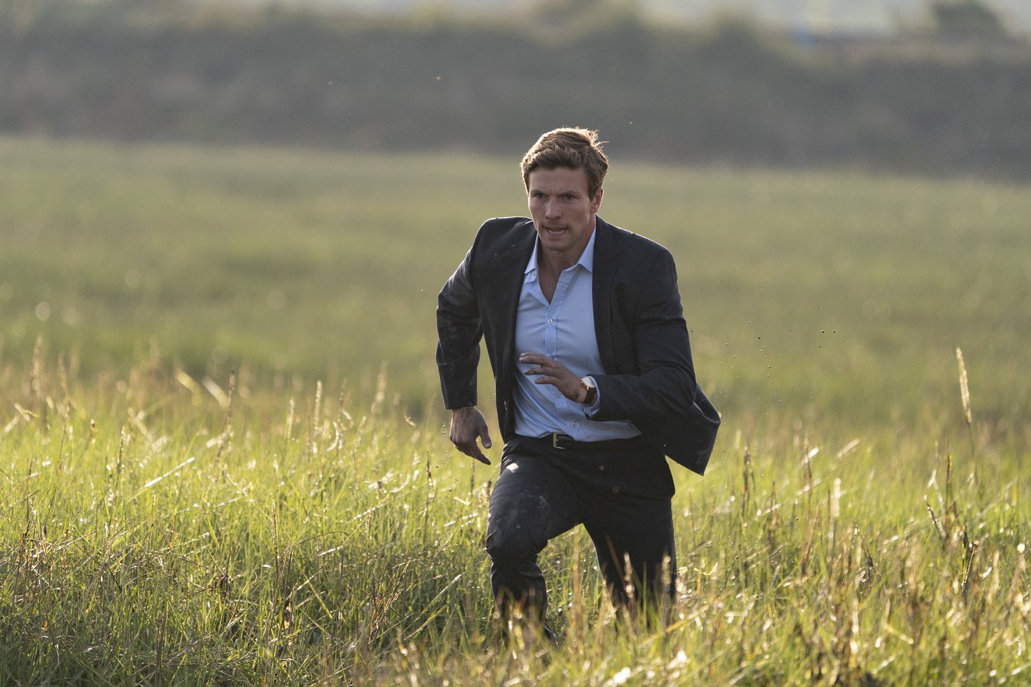 Leo Suter as DI Tommy Lynley running through the marsh
